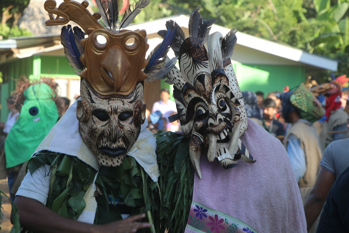 2 Personen mit Boruca Holzmasken